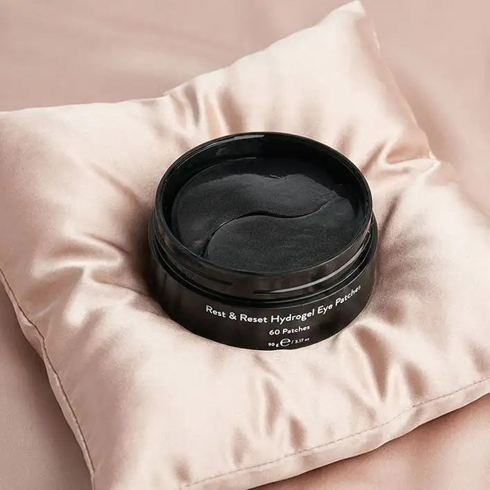 Black cylindrical container of rest & reset hydrogel eye patches with a glossy finish and white text labeling.
