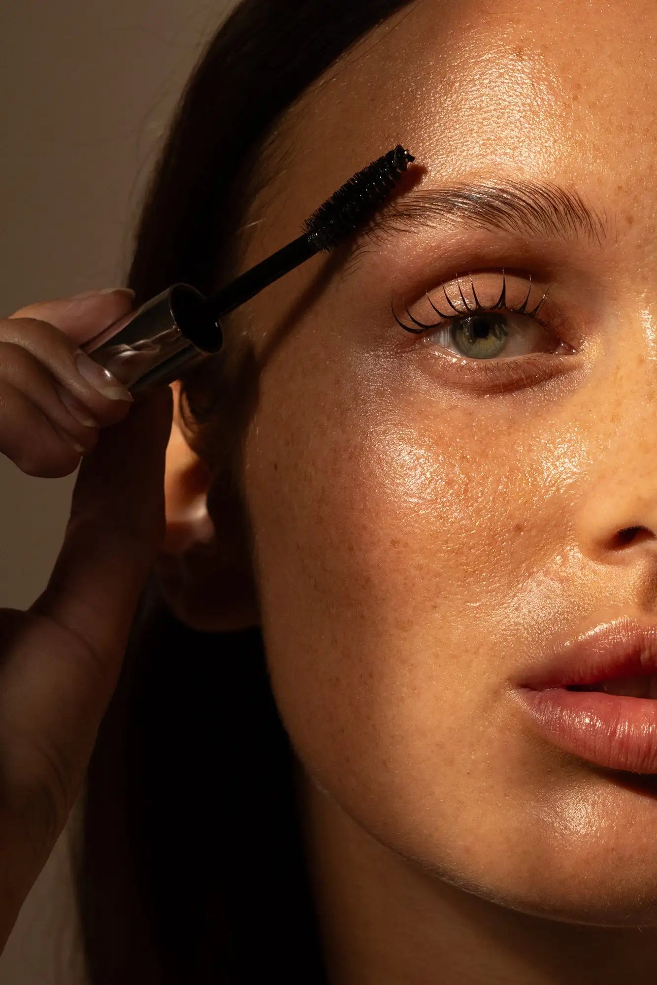 Black mascara wand with a clear, cylindrical tube.