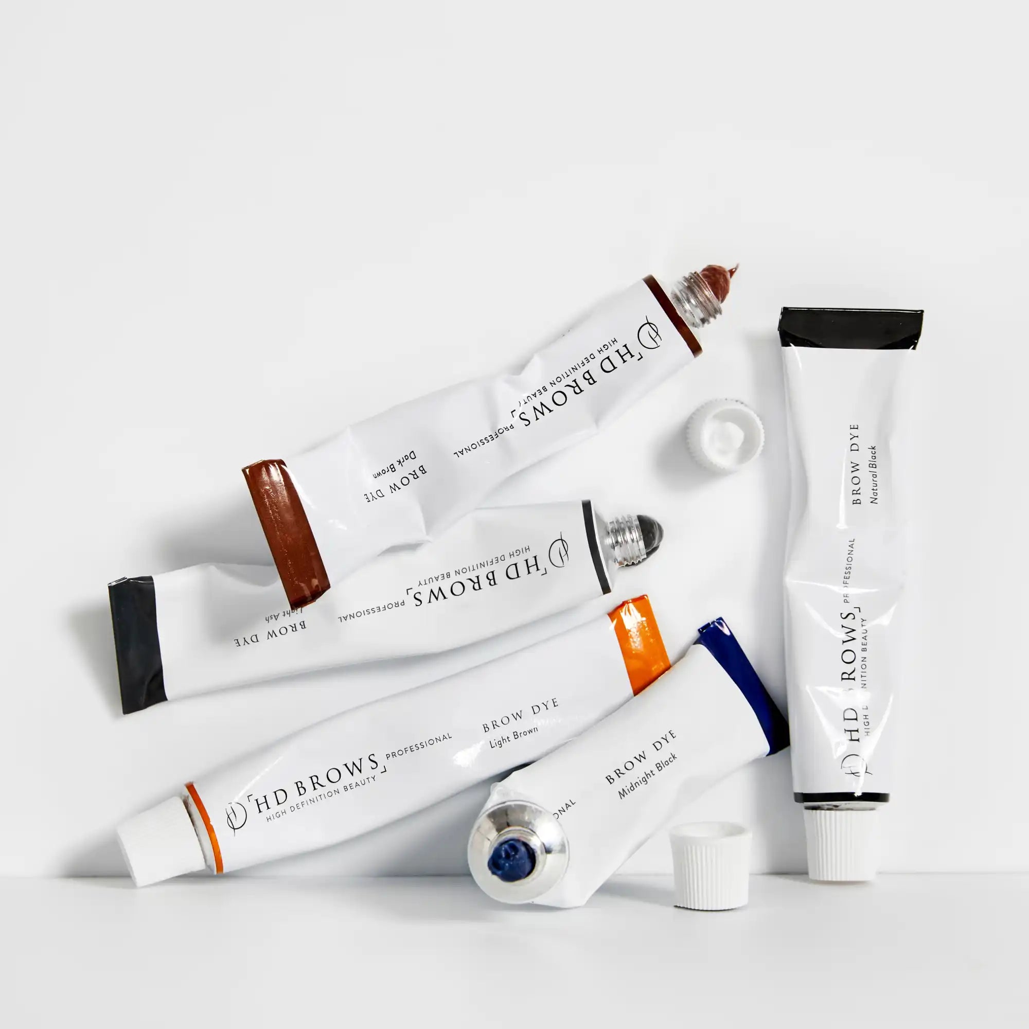 Assorted tubes of brow dye in various shades.