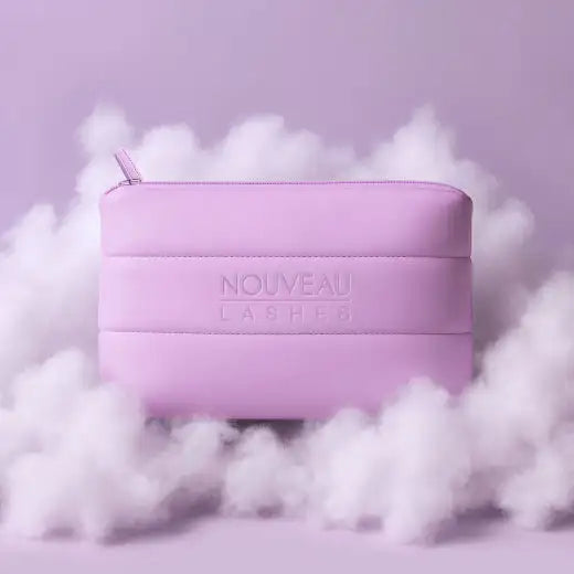 A soft lavender faux leather pouch with a subtle embossed ’nouveau lashes’ logo and a matching zipper pull.
