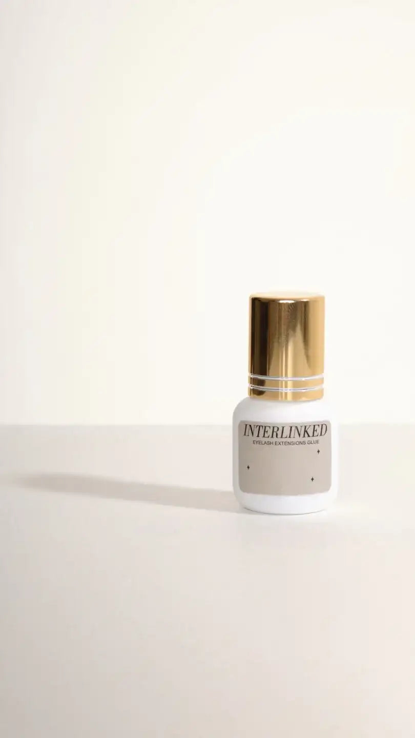 White and gold nail polish bottle with ’interlinked’ text.